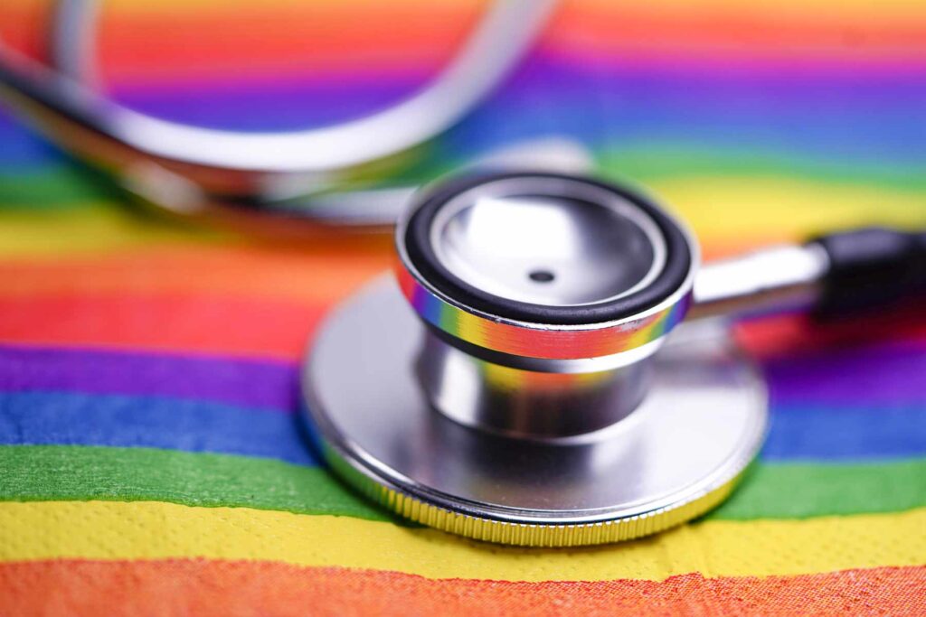 A stethoscope lies atop a rainbow flag