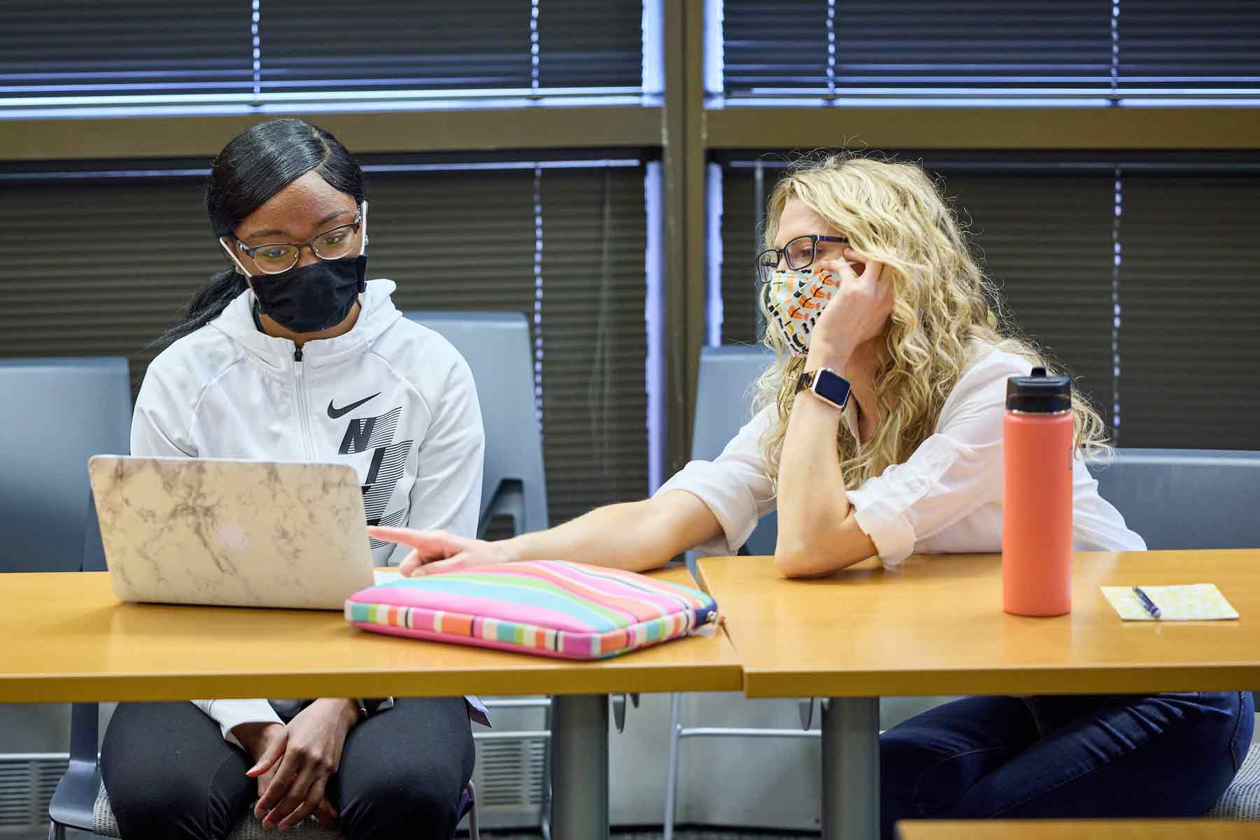 Summer scholar Jakayla Folarin-Hines, left, meets with Victora Brings, PhD, right, to present and get feedback on her research.