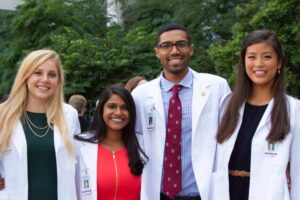 Incoming medical students pose for a smile after receiving their white coats